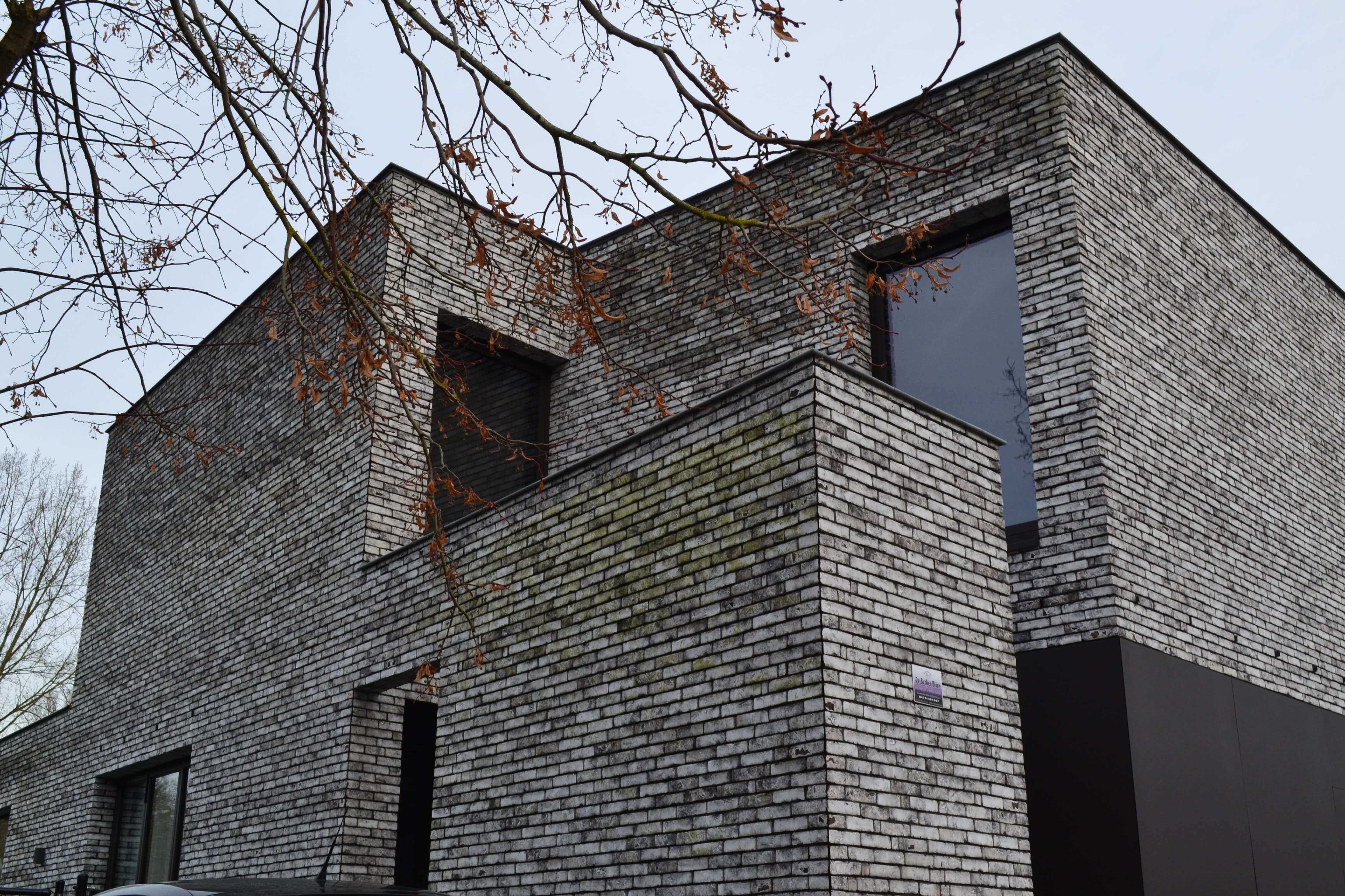 zij-en voorgevel nieuwbouwwoning lichtgrijze moderne gevelstenen